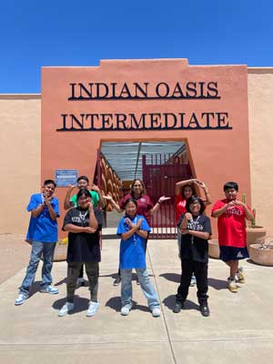 students doing hand signs