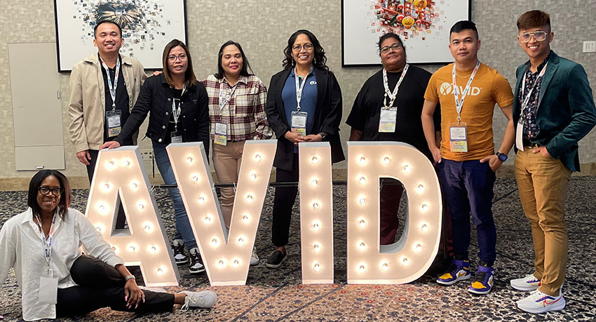 Staff member group photo in front of AVID sign
