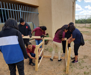 Group of students building a wooden structure