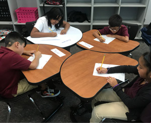 Four students sitting at their desks